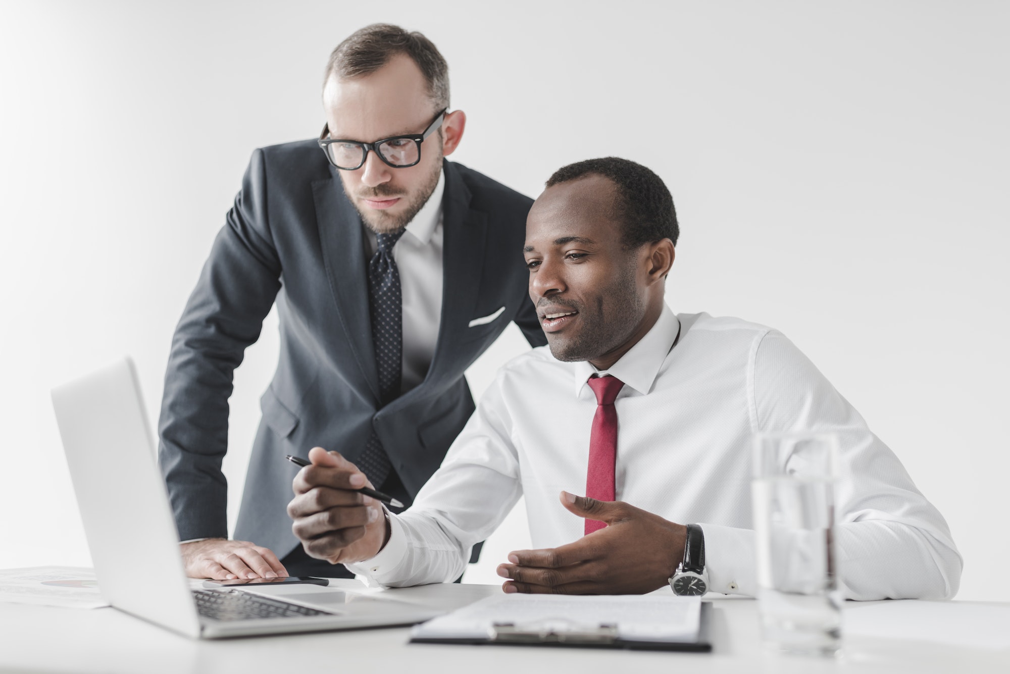 multicultural businessmen working on laptop together at workplace